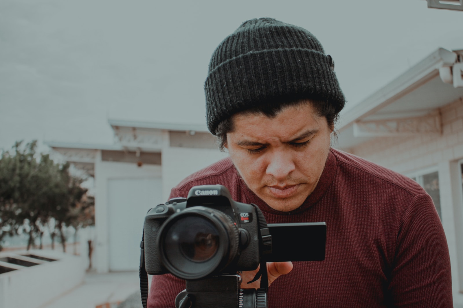 a man holding a camera and looking at it