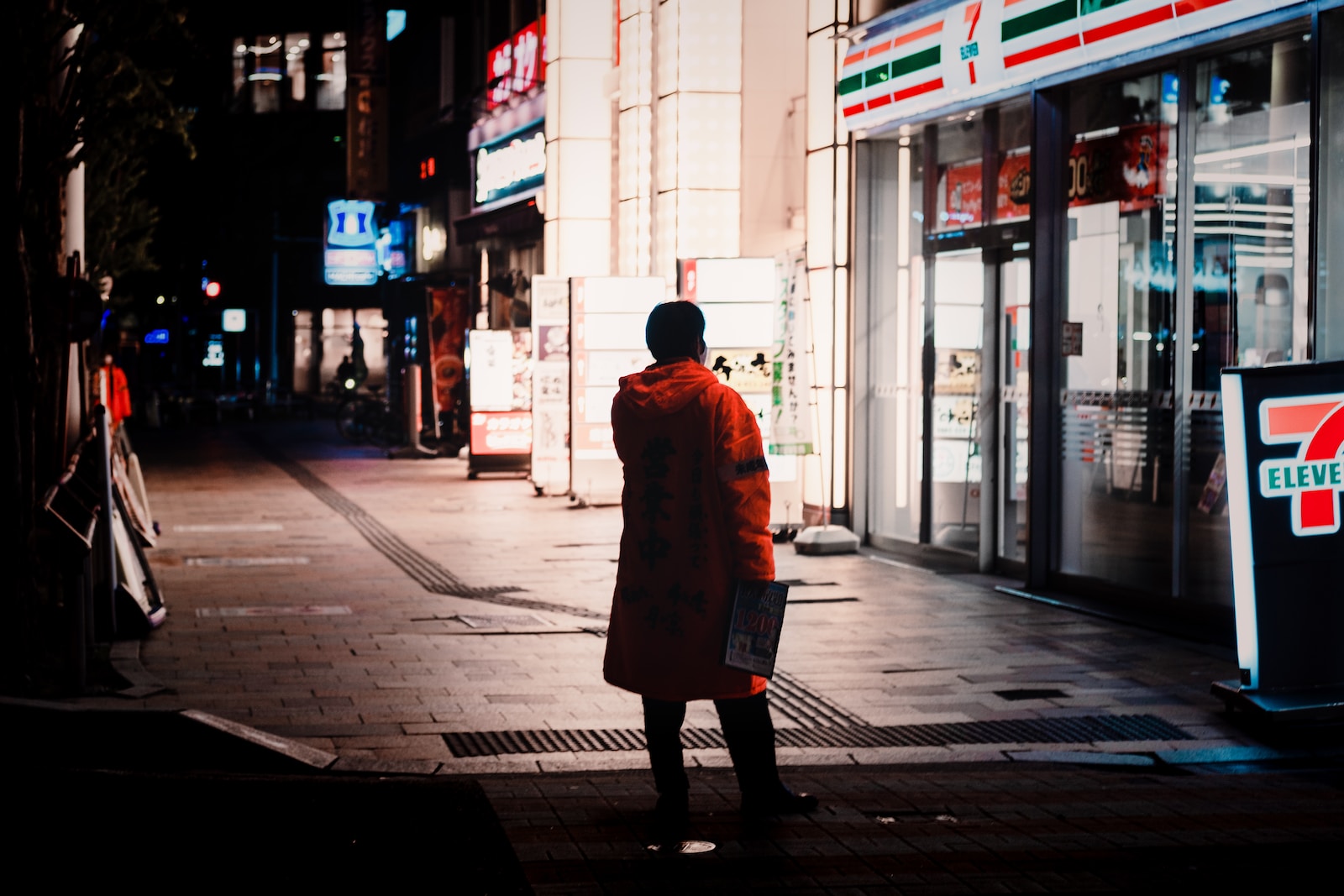 woman in brown coat walking on sidewalk during daytime